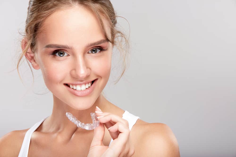 Young Woman Holding Clear Aligner